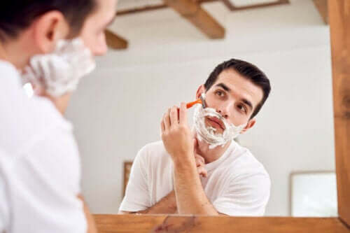 Aynaya bakarak tıraş olan bir adam.