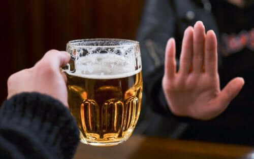 Bir bardak bira uzatılıyor ve karşı taraf eliyle reddediyor