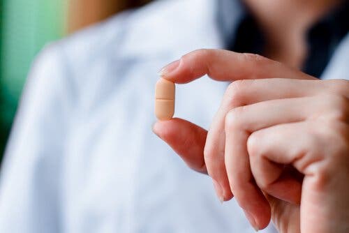 Elinde bir antibiyotik tutan bir doktor.