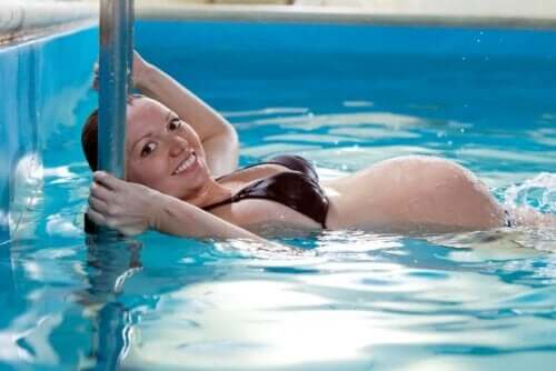 Havuzda egzersiz yapan hamile bir kadın.