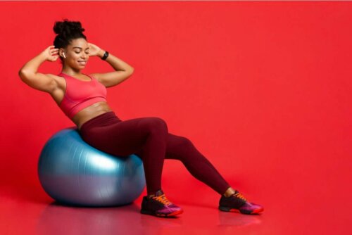 Bir yoga topu ile egzersiz yapan kadın.