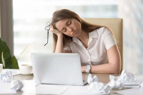 Yorgun bir kadın bilgisayar başında oturuyor