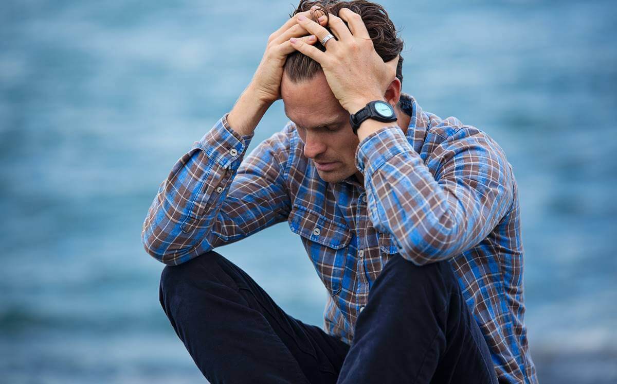 başını ellerinin arasına almış bir adam