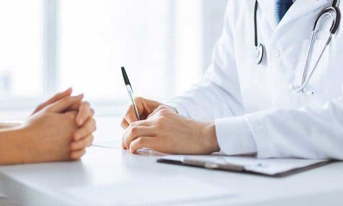 Hastasının tıbbi öyküsünü almakta olan bir doktor.