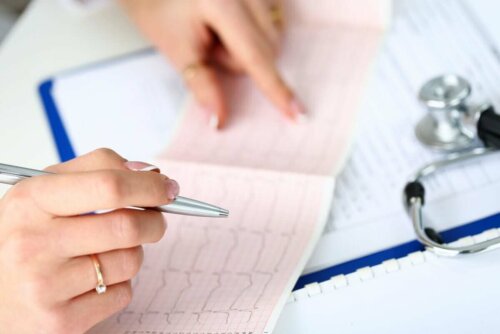 Bir elektrokardiyogramı inceleyen bir doktor.