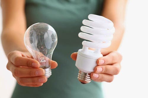Evindeki daha önceki ampulleri LED ampuller ile değiştiren bir kişi.