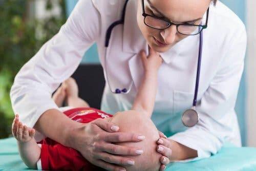 Bir bebeği kontrol etmekte olan bir doktor.