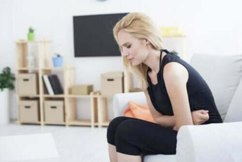 Midesinde bir acı hisseden bir kadın.