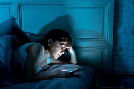 Yatmadan önce telefonda vakit geçiren kadın