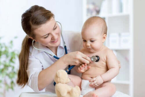 Bir doktor bir bebeği muayene ediyor