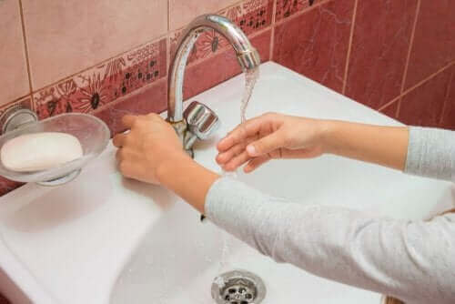 Elini yıkayan bir kişi.