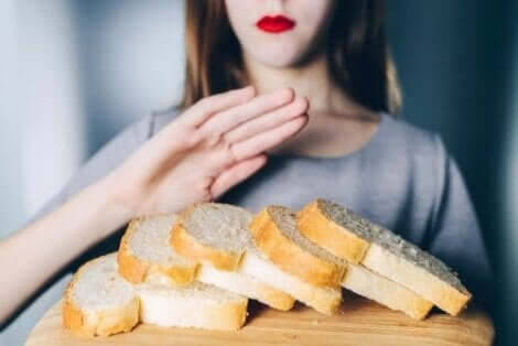 Bir kadının önünde ekmek dilimleri duruyor kadın elleriyle ekmeklerin önünü kapatıyor