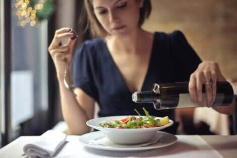 bir kadın salatasına zeytinyağı döküyor
