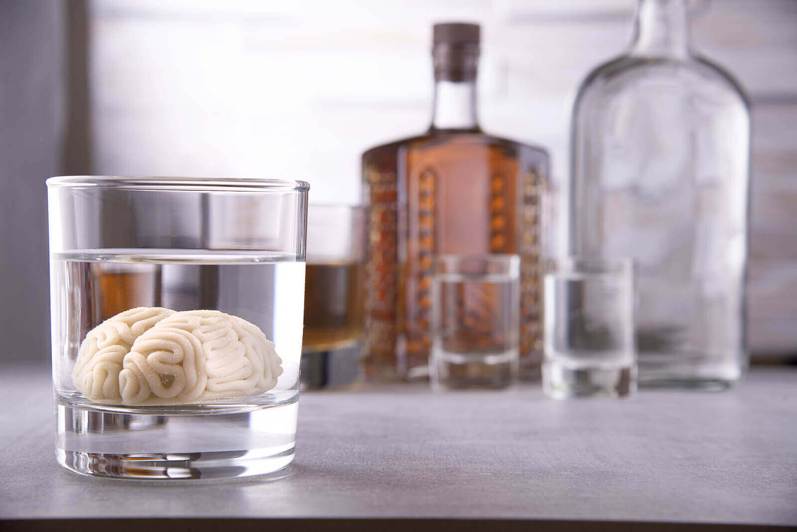 alkol şişeleri ve bir bardak alkole yatırılmış beyin