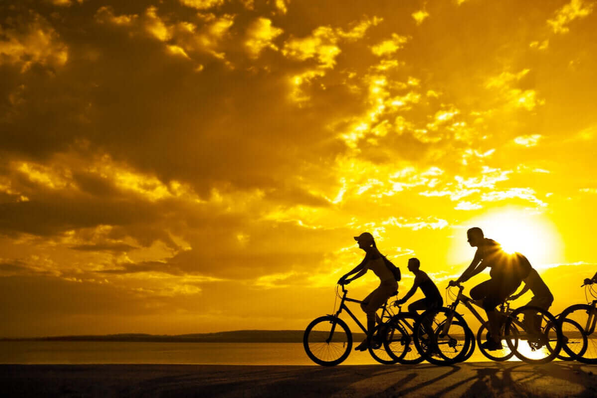 gün batımında bisiklete binen insanlar