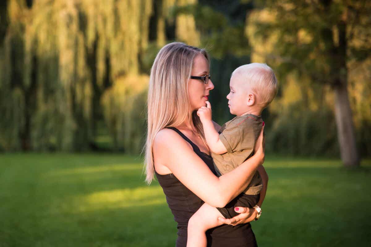 kucağında bebeğiyle ilgilenen anne