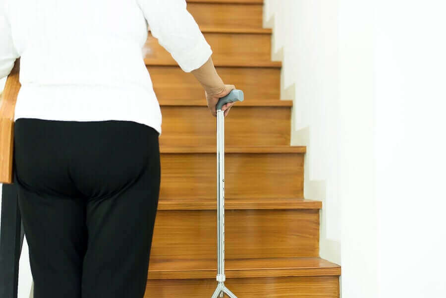 merdivene bastonla yürüyen kişi