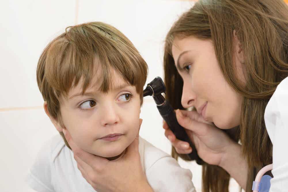 çocuğun kulağını kontrol eden doktor