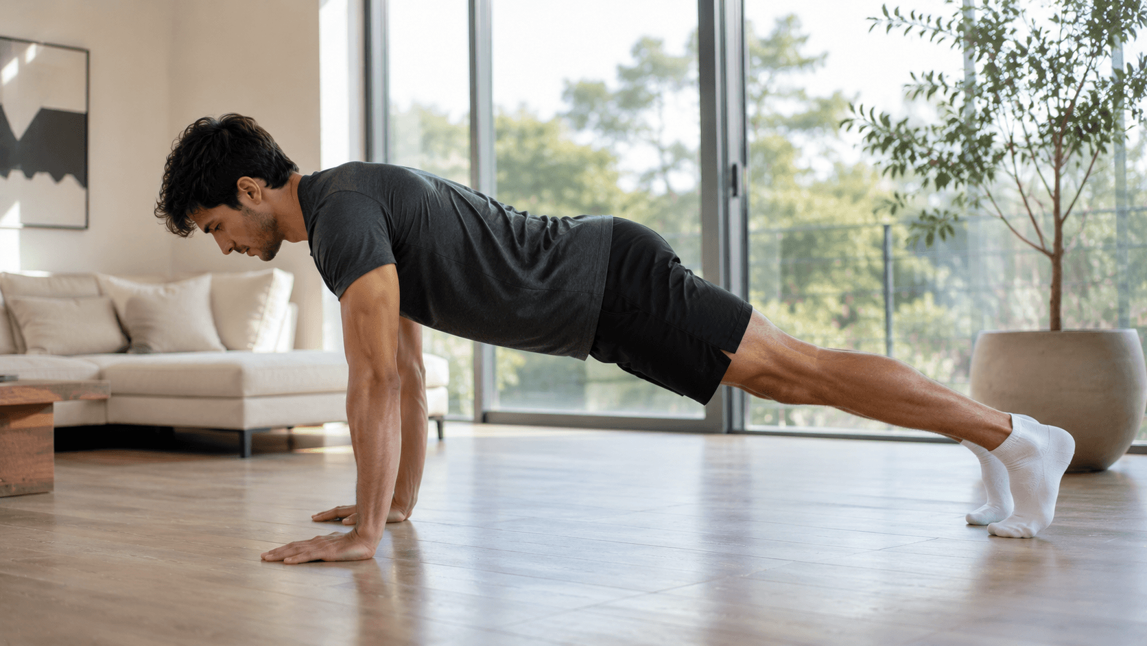 Hombre realizando una plancha con calcetines sobre una superficie lisa para fortalecer el abdomen y el core en casa.